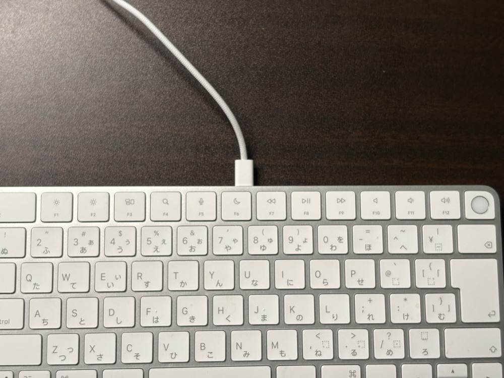 キーボードの奥の面にUSB-Cケーブルを挿して充電しているところ